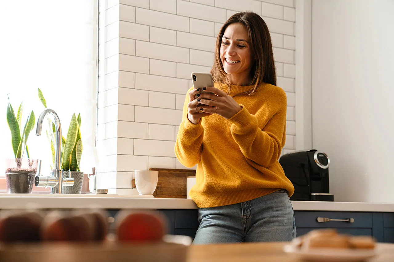 Homeowner researching kitchen and bath ideas on her phone during a renovation