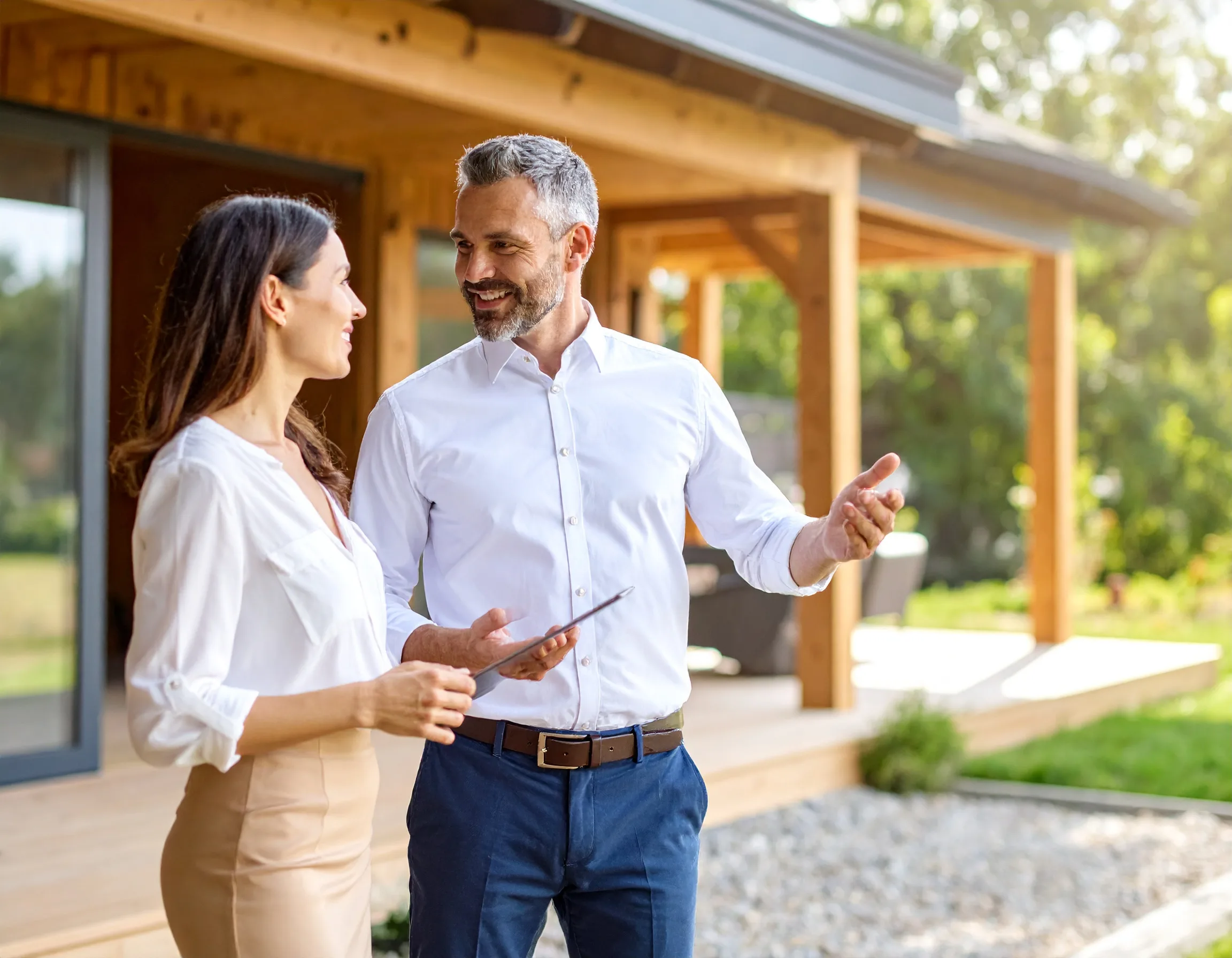 Remodeler presenting a completed project to a homeowner outside their home
